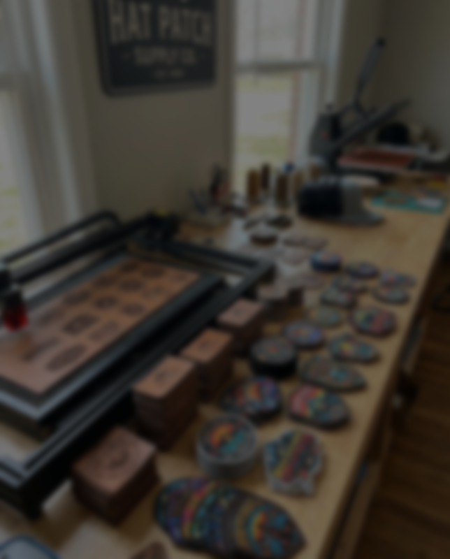 Workbench with patches and a 'Hat Patch Supply Co.' sign in the background