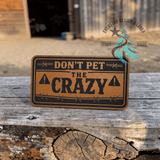 Close-up of the engraved Don't Pet the Crazy leather hat patch