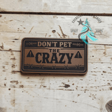 Don't Pet the Crazy leather hat patch shown at an angle