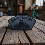 Leather hat patch reading Don't Test My Fence Line in country styling