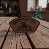 Don't Test My Fence Line leather hat patch shown at an angle