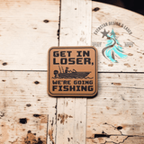 Close-up of the engraved Get in Loser, We're Going Fishing leather patch