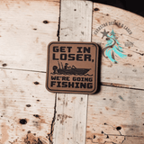 Get in Loser, We're Going Fishing leather hat patch shown at an angle