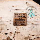 Close-up of the engraved Get in Loser, We're Going Hunting leather patch