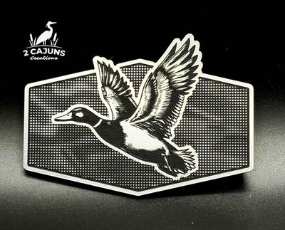 Dual layer stainless and black acrylic hat patch with a mallard duck on linen camo