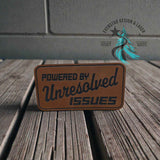Leather hat patch reading Powered by Unresolved Issues