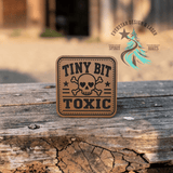 Laser engraved leather hat patch reading Tiny Bit Toxic