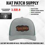 Hat patch with 'Trouble Maker' lettering in a bold engraved style